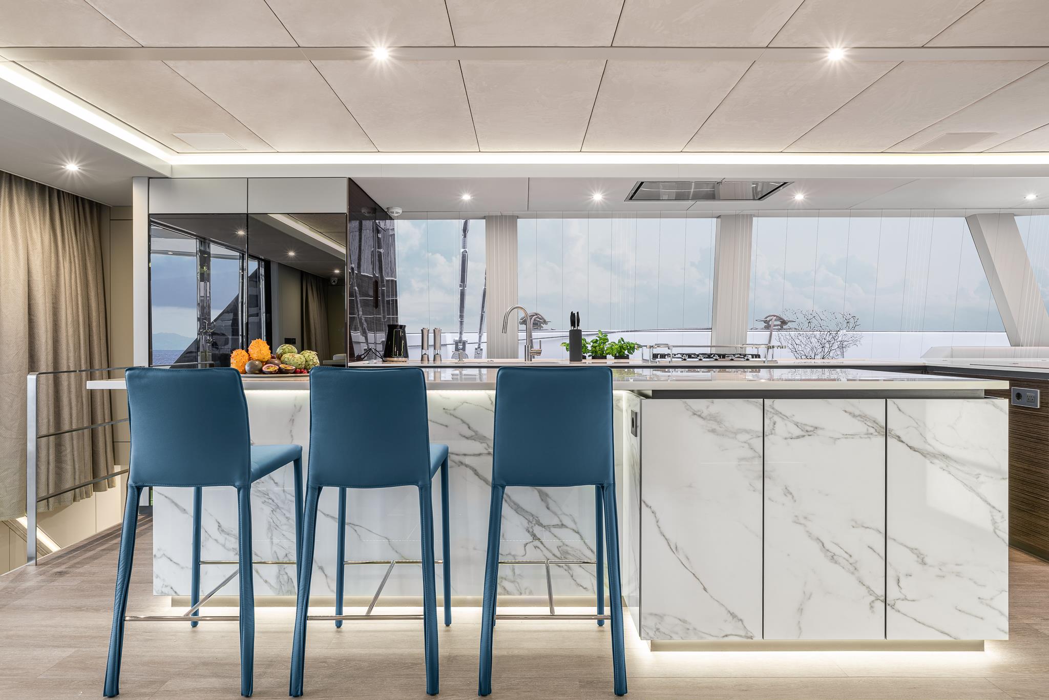 Galley bar with blue stools and marble counter